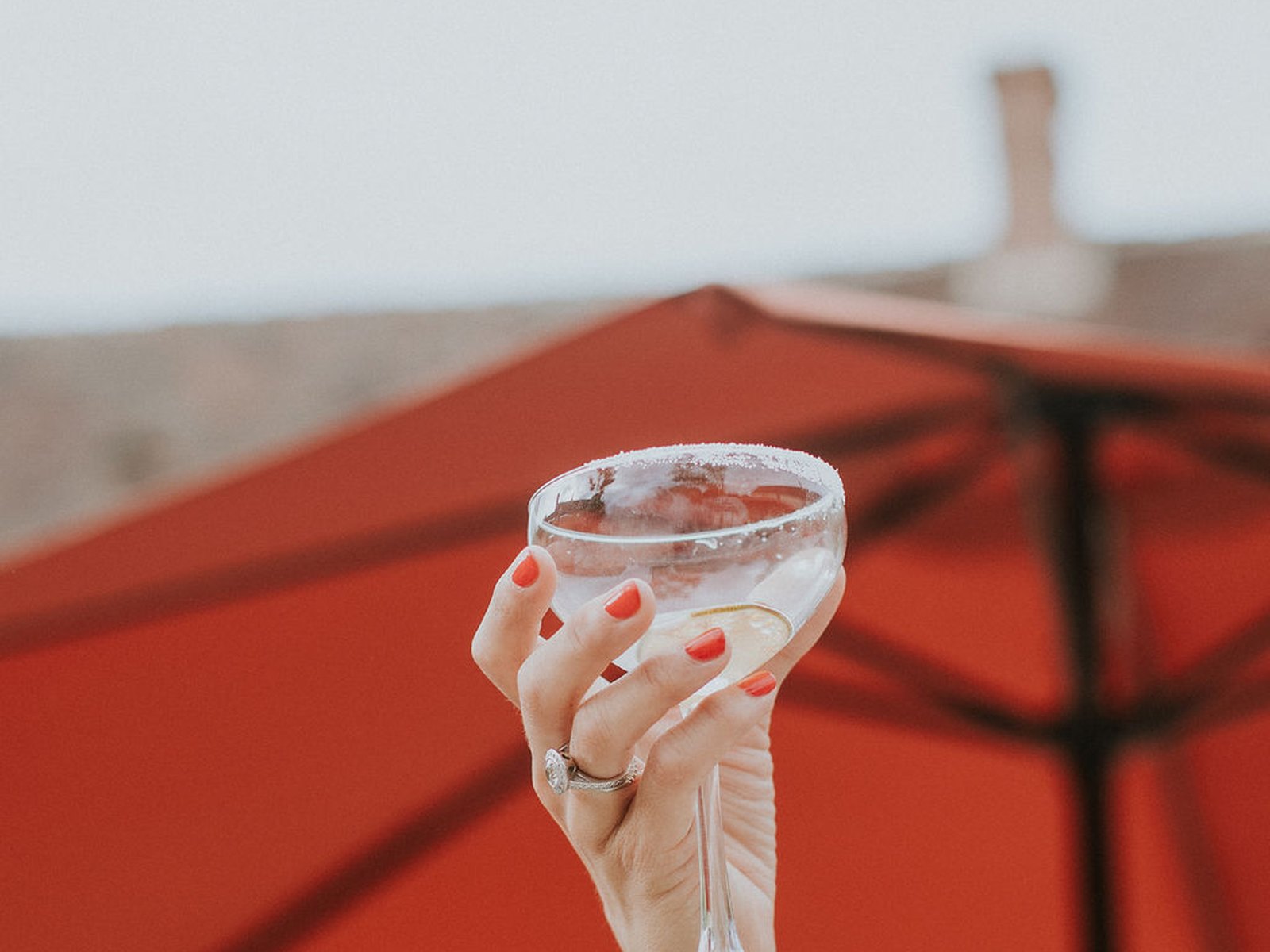 Une coupe levée sous les parasols du cocktail