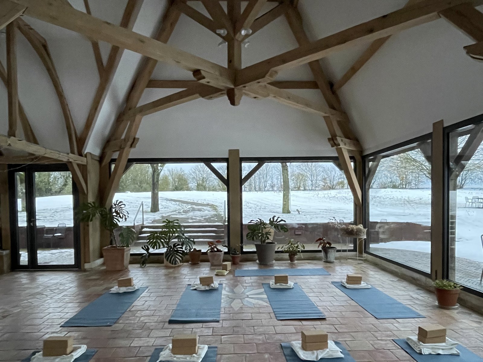 Cours de yoga sous la charpente du jardin d'hiver